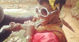 Waje having fun with a baby crocodile