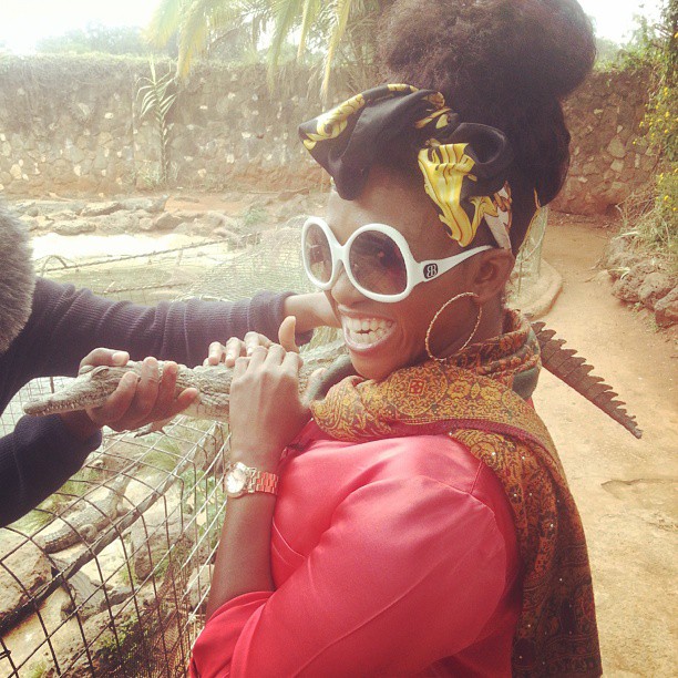 Waje having fun with a baby crocodile