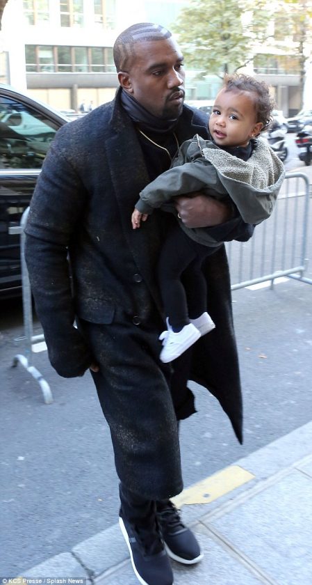 North West all smiles as Kanye holds her