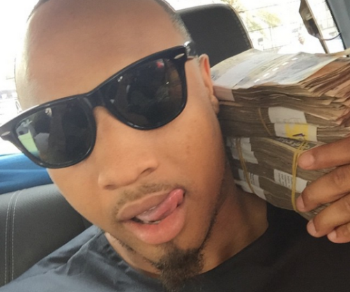 B-Red poses with wads of Naira notes