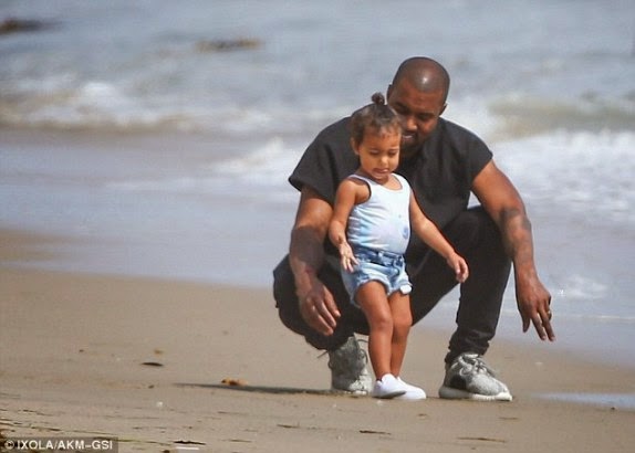 Kanye West and his daughter at the beach