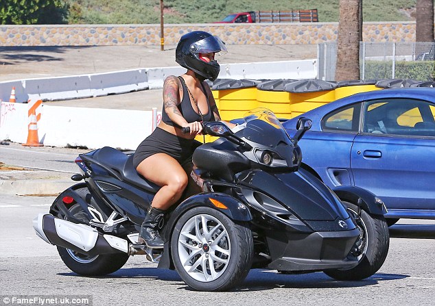 Amber Rose displays sexy curves as she rides sports bike