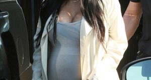 Kim Kardashian puts her growing baby bump