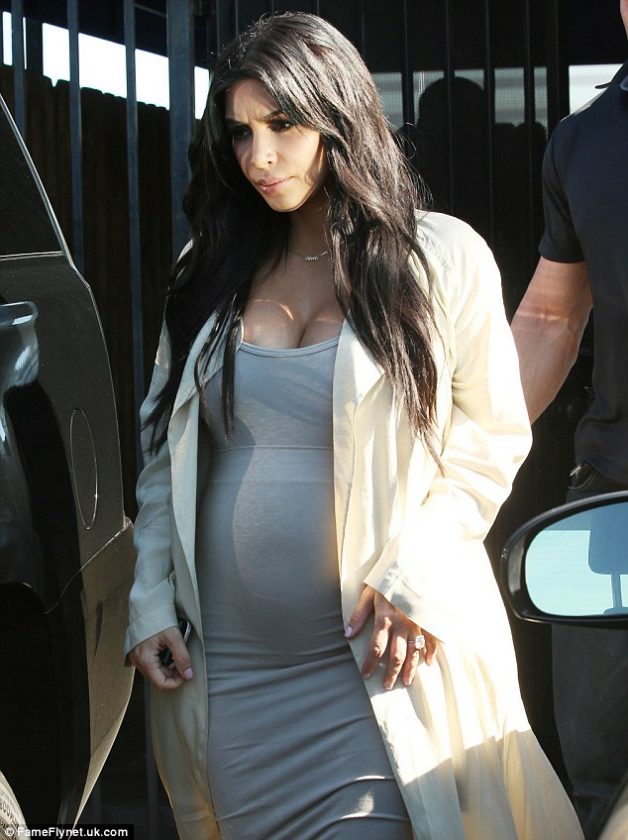 Kim Kardashian puts her growing baby bump