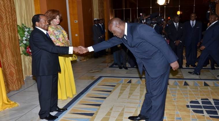 Cameroon's Minister of Sports and Physical Education Pierre Ishmael Bidoung Kpwatt (right) greets President Paul Biya